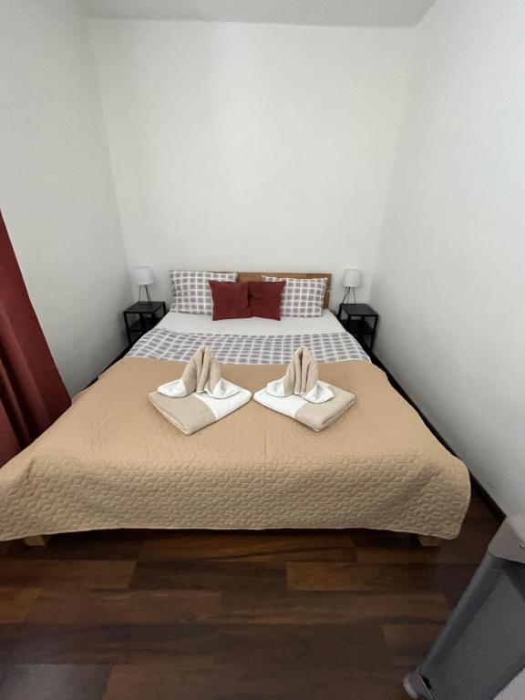 a bedroom with a bed with two shoes on it at Apartments Nifia in Liptovský Ján