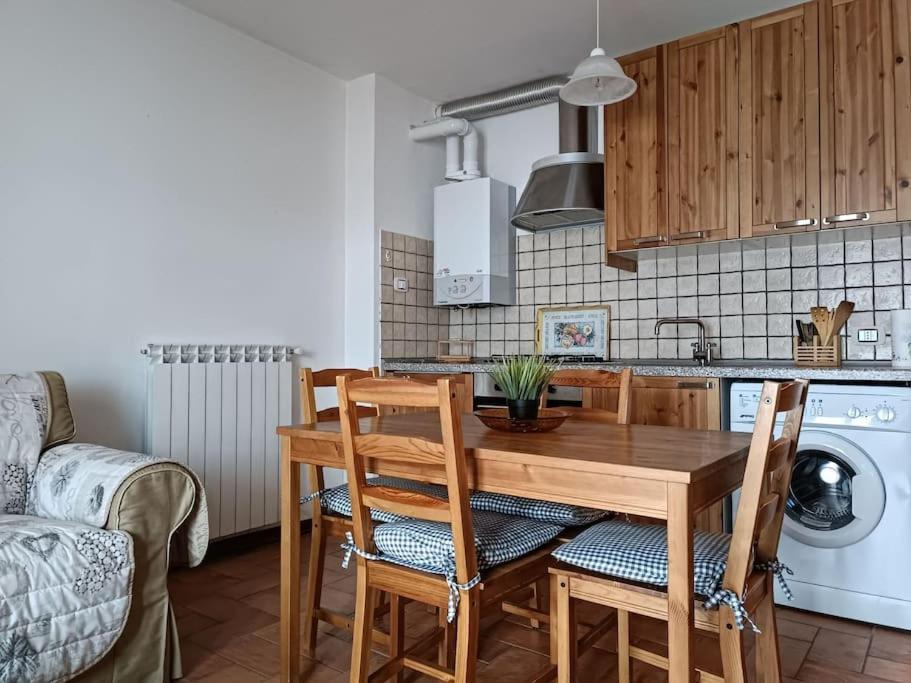 cocina con mesa de madera y sillas en Vista Panoramica ALTOPIANO DELLE ROCCHE en Terranera