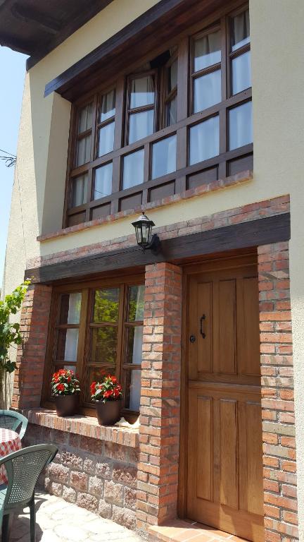 een huis met een houten deur en ramen bij EL COLLAU in Llanes
