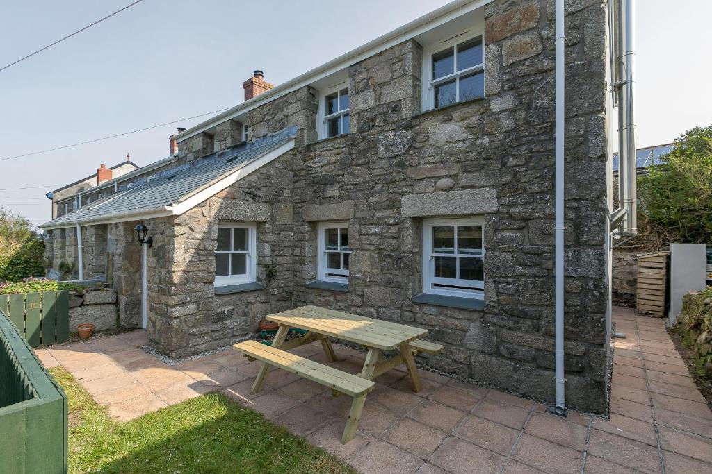 a picnic table in front of a stone house at 15 Boscaswell Downs in Penzance