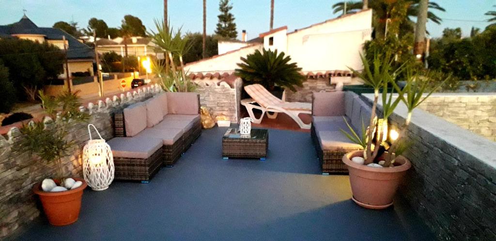 坎布里爾斯的住宿－Villanoelia Beach No fiestas，屋顶上种有长沙发和盆栽植物的庭院