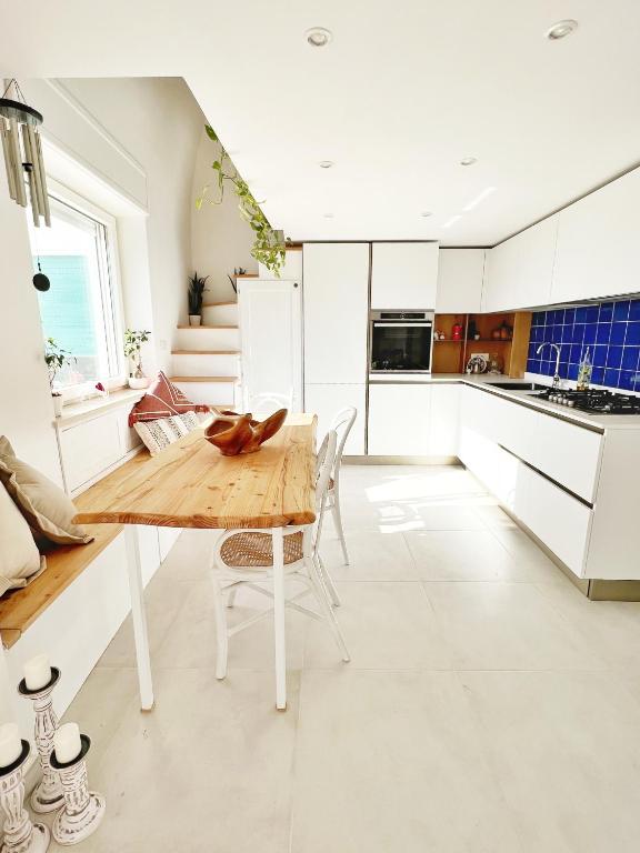 een keuken met een houten tafel en witte kasten bij Casa Maddy Anacapri in Anacapri