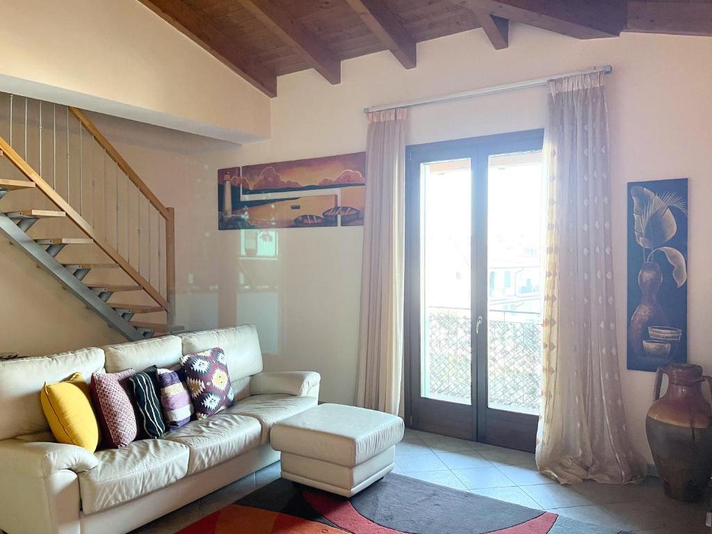 uma sala de estar com um sofá e uma porta de vidro deslizante em La Mansarda del Viandante em Castelbelforte