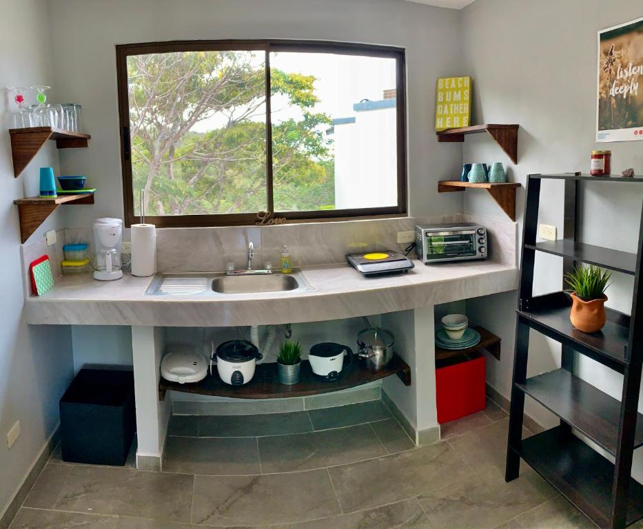 een keuken met een wastafel en een raam bij Casa Allegria in Tamarindo