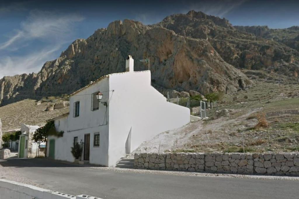 un edificio blanco al lado de una montaña en Casa de Mirasierra, en Bedmar
