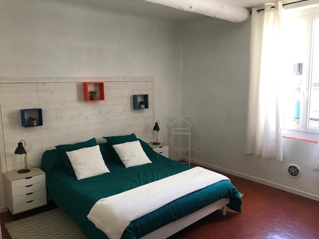 Un dormitorio con una cama verde y blanca y una ventana en Grande Maison Village proche Verdon avec garage pour moto vélo, en Salernes