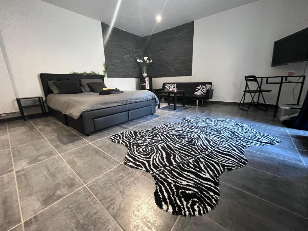 a bedroom with a bed and a zebra rug on the floor at Chambre studio tout confort in Boussu