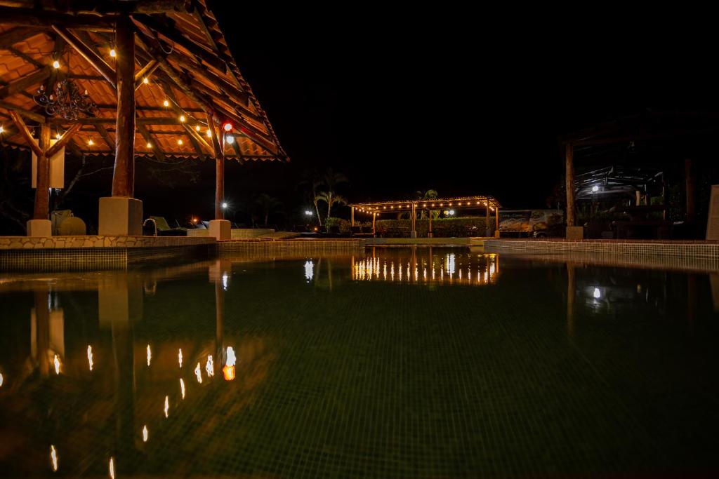 una piscina de agua por la noche con luces encendidas en Hotel El Rancho, en Quepos