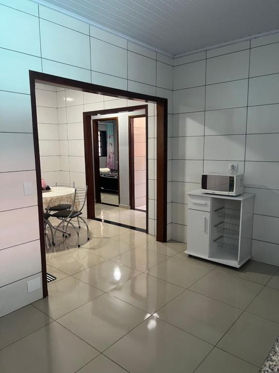 une pièce avec une cuisine équipée d'un micro-ondes et d'une table dans l'établissement Residencia Canterville, à Olímpia