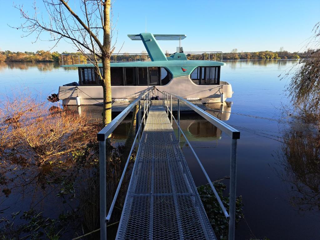 a boat is docked on the water with a dock at Casa barco Valada in Morgado