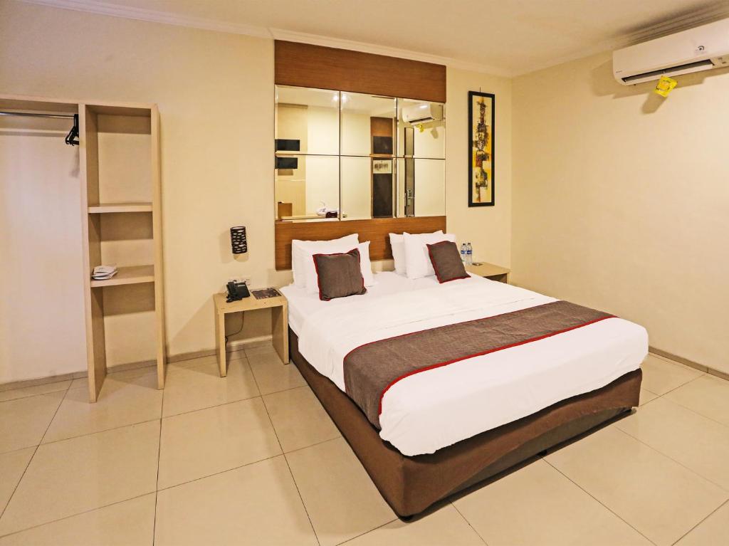 ein Schlafzimmer mit einem großen Bett in einem Zimmer in der Unterkunft Super OYO Townhouse OAK Hotel Fiducia Serpong in Serpong