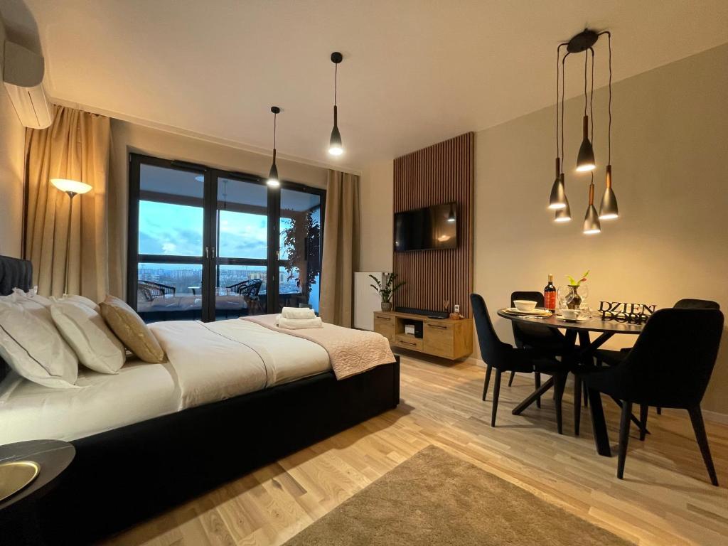 sypialnia z łóżkiem i jadalnią w obiekcie VISTULA TERRACES 10th floor w Krakowie