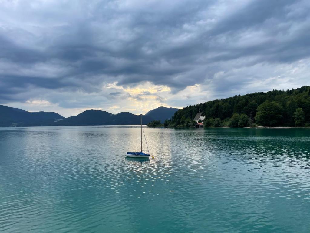 a sail boat in the middle of a lake at Ferienwohnung am Walchensee in Walchensee