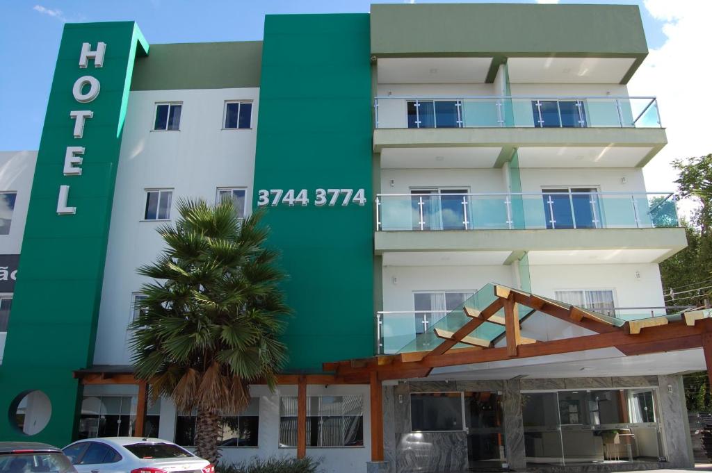 a building with a green and white at Hotel Serrano in Frederico Westphalen