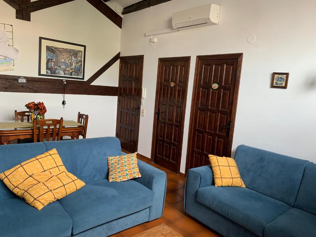 a living room with two blue couches and a table at Apartament Cal Negre in Vilassar de Mar