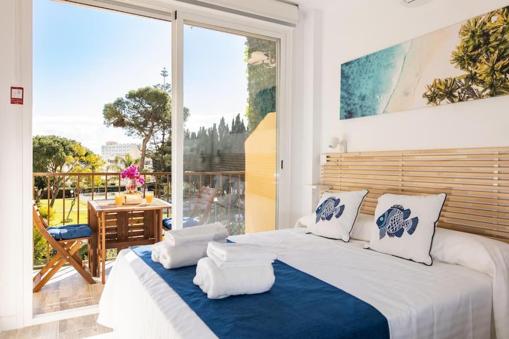 ein Schlafzimmer mit einem großen Bett und einem großen Fenster in der Unterkunft Enjoy La Carihuela Beach at 4 Min.Terrace & Pool. in Torremolinos
