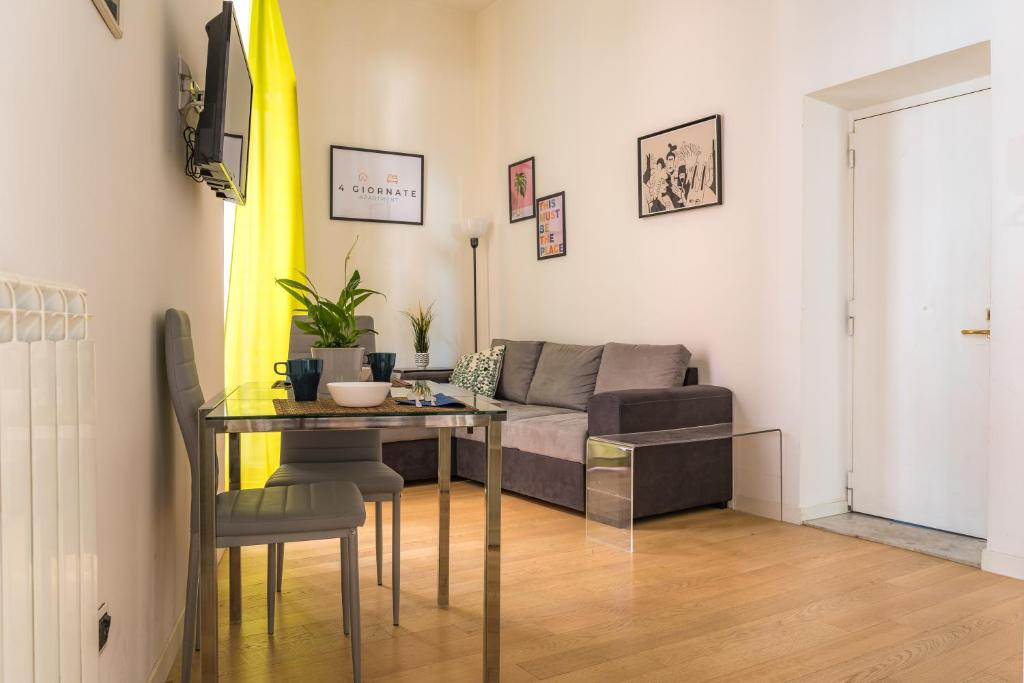 sala de estar con mesa y sofá en 4 Giornate Apartment en Nápoles