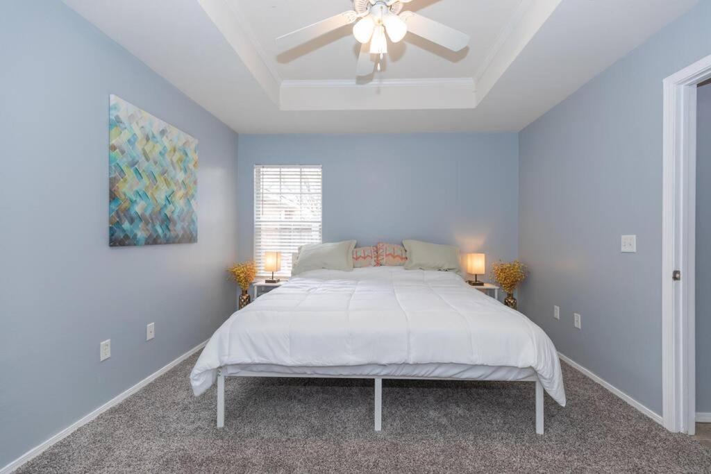a white bedroom with a bed and a ceiling fan at Work Remote - minutes to I-27/I-40/Downtown in Amarillo