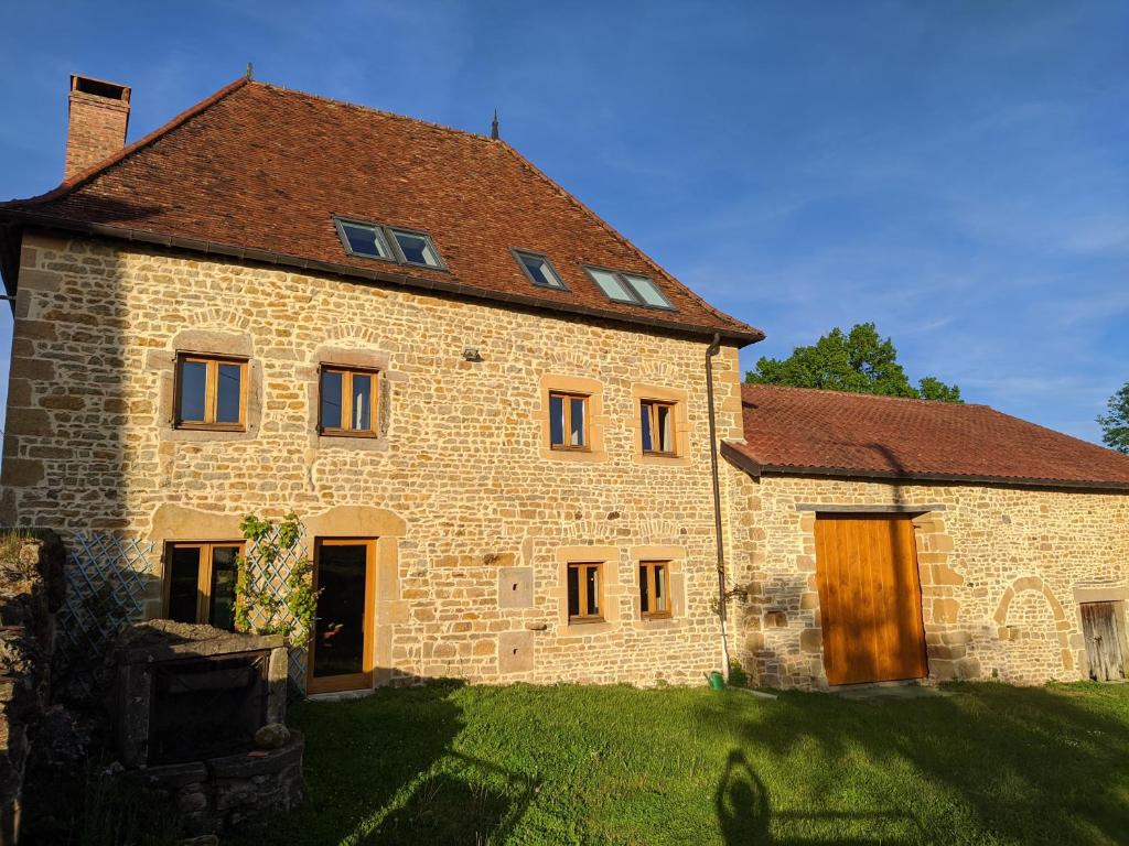 a large brick building with a brown roof at Le Nid du Hibou in Saint-Julien-de-Civry