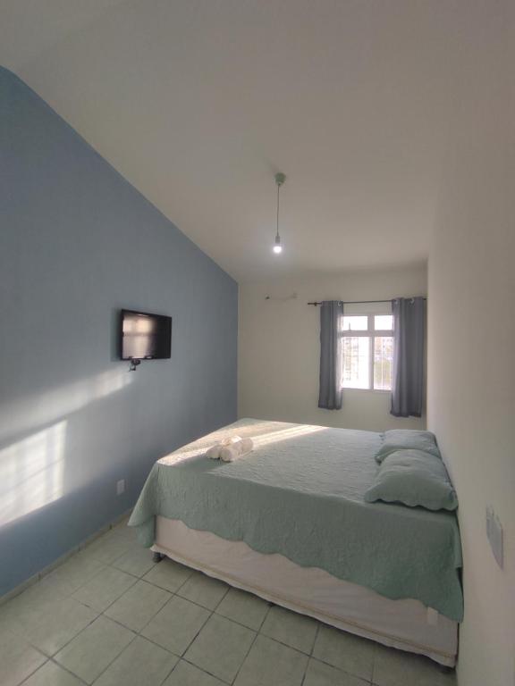 1 dormitorio con 1 cama y TV en la pared en Pousada Encanto dos Mares en Natal