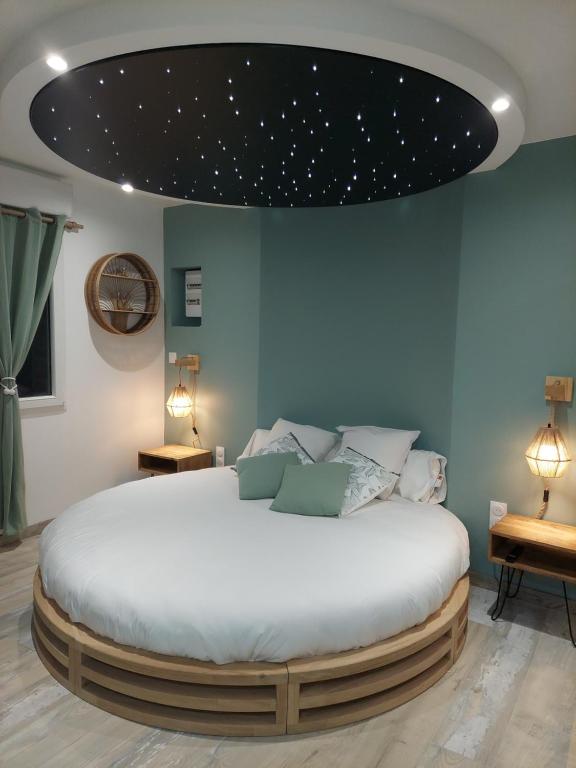- une chambre dotée d'un grand lit avec des étoiles au plafond dans l'établissement Au Spa d'eau pâle, à Ferques
