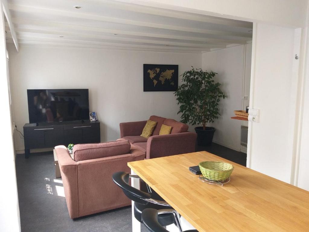 a living room with a couch and a table at Appartement Rosendael proximité plage Malo les bains in Dunkerque