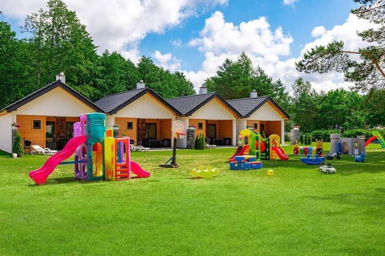 a yard full of playground equipment in front of a house at Holiday homes with fireplaces, Jaroslawiec in Jarosławiec