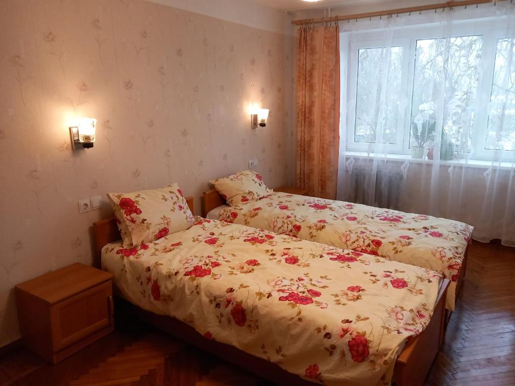 niewielka sypialnia z 2 łóżkami i oknem w obiekcie Sunflower w Jurmale