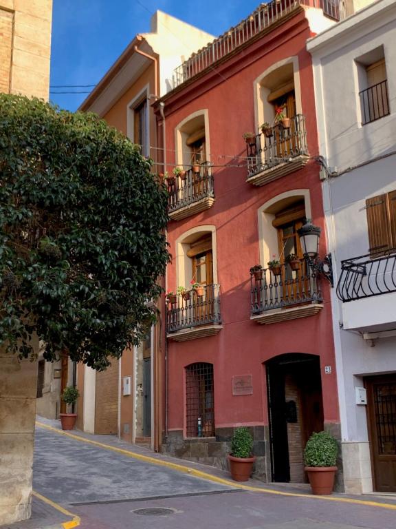 Las Puertas Del Indiano في Relleu: مبنى احمر بشرفات على شارع