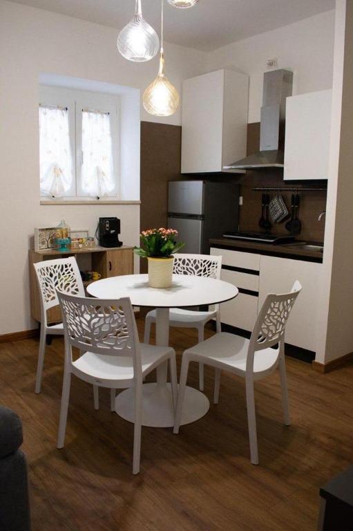 a kitchen with a white table and chairs in a room at M&G holiday house in Matera