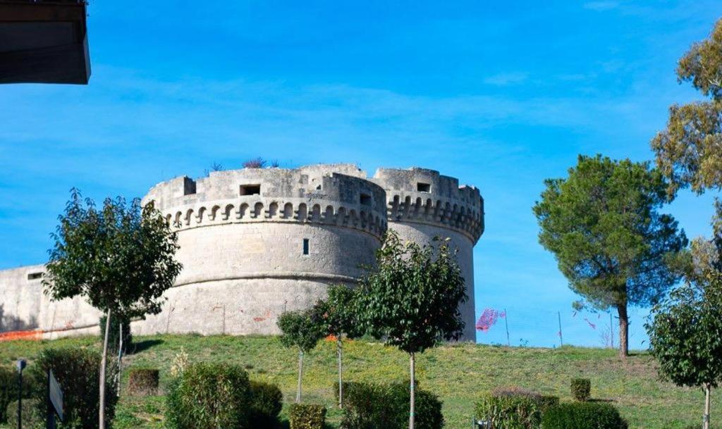 a castle on a hill with trees in front of it at M&G holiday house in Matera