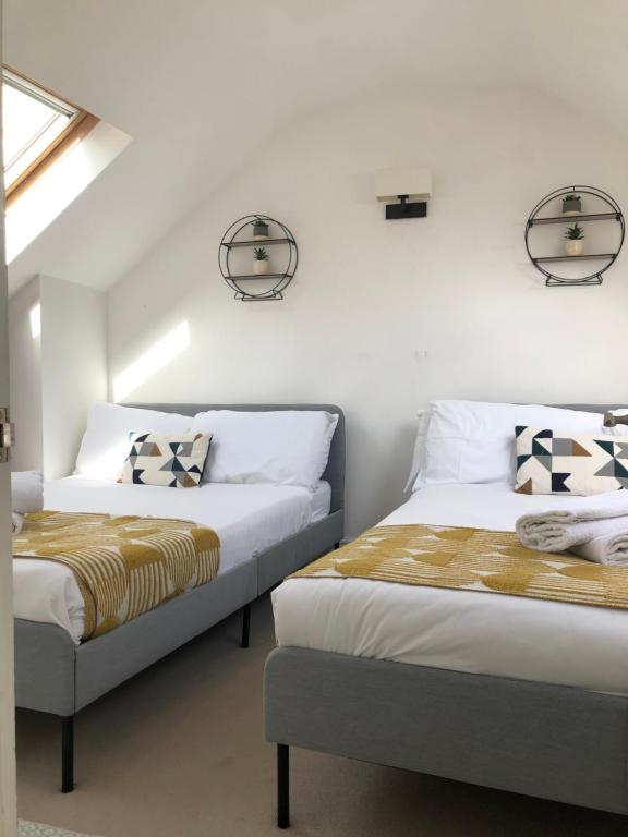 two beds sitting next to each other in a bedroom at Stylish property, off street parking,pet friendly in Bath