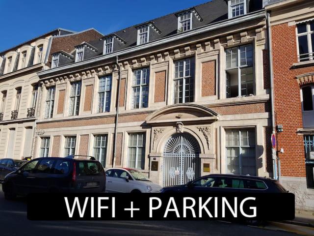 um edifício com carros estacionados em frente em Lille centre parking privé gratuit très calme em Lille