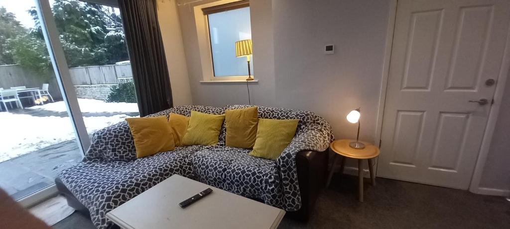 a living room with a couch with yellow pillows at Spacious 2 Bed, Free Parking, Free Wifi - Serene Homes Sheffield in Hillsborough