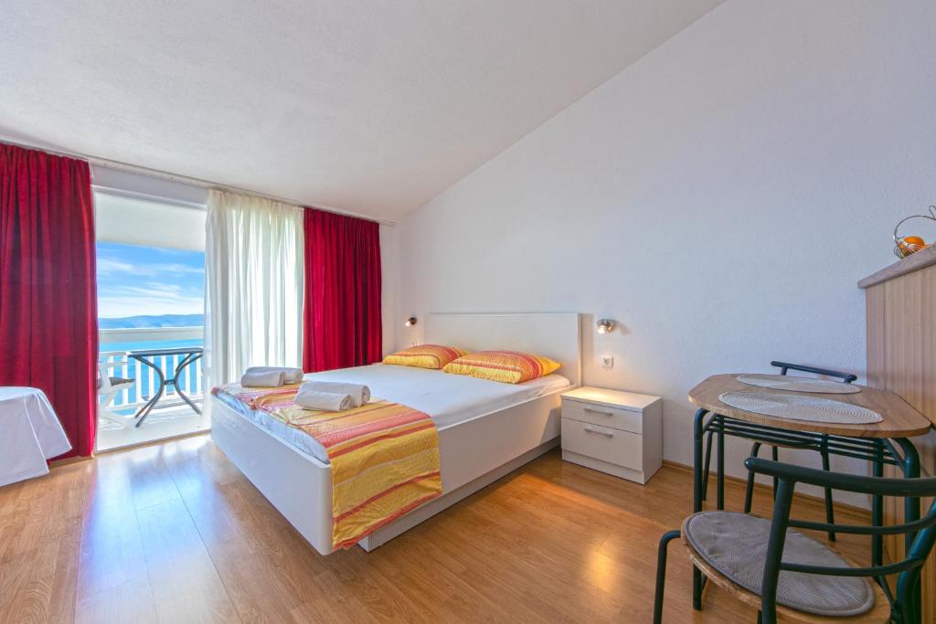 a bedroom with a bed and a balcony at Adria Brela Apartments in Brela