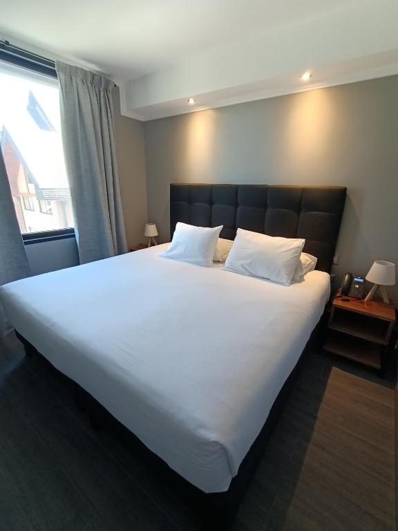Una cama o camas en una habitación de Hotel Enjoy Pucón