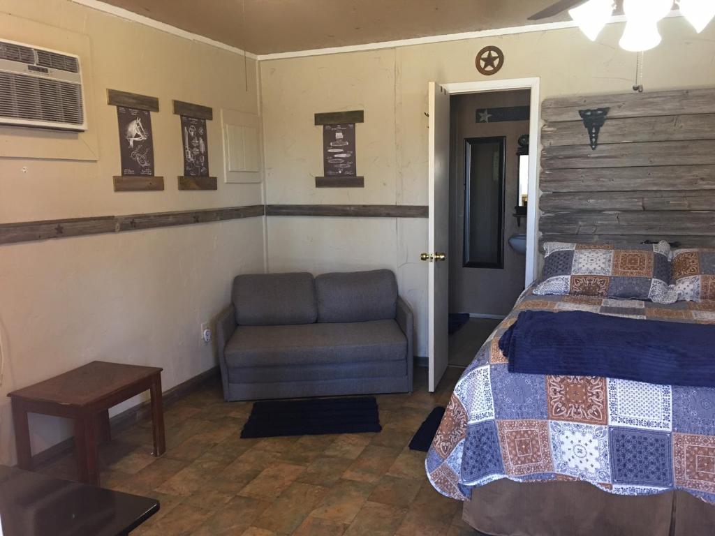 a bedroom with a bed and a chair at Acorn Hideaways Canton Rustic Old West Frontier Suite in Canton