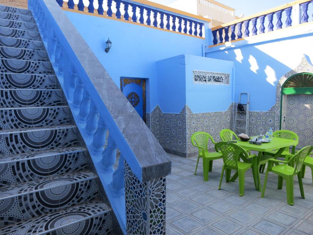un patio con tavolo, sedie e scala di Casa Morisca a Sidi Ifni