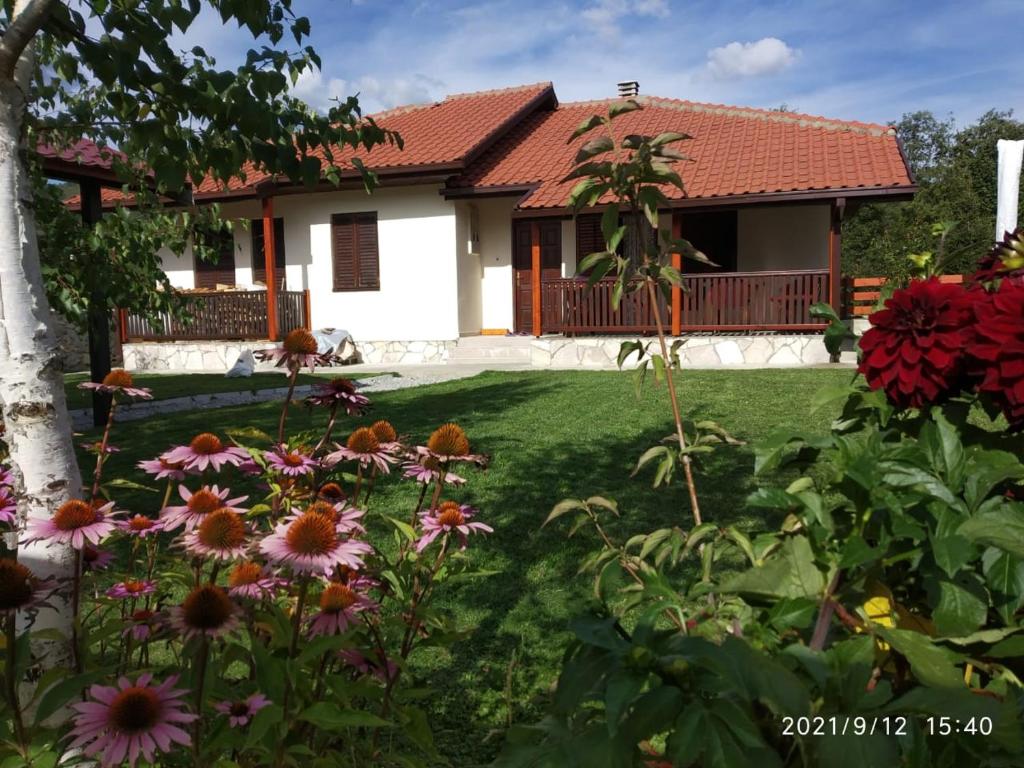 einen Garten vor einem Haus mit Blumen in der Unterkunft Bjelasica Home in Kolašin