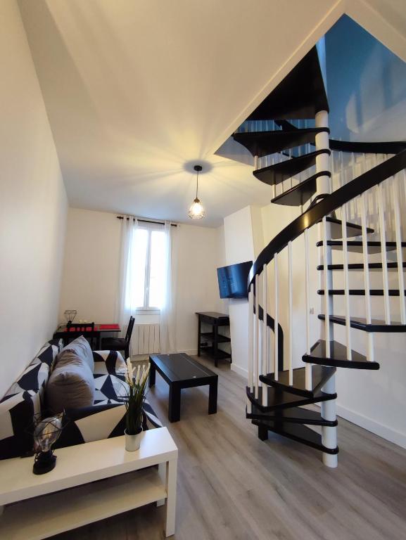 ein Wohnzimmer mit einer Treppe und einer Couch in der Unterkunft La vie en blanc et noir Maisons-Laffitte in Maisons-Laffitte