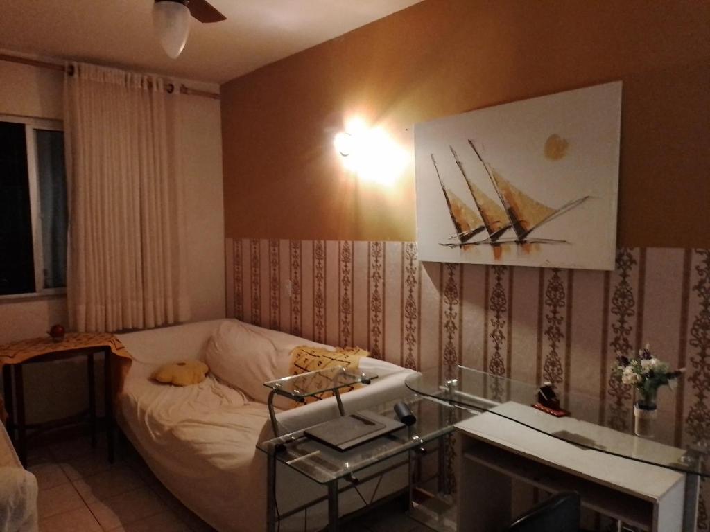 Habitación pequeña con cama y pintura de un barco en Apartamento, vista cidade, en Salvador