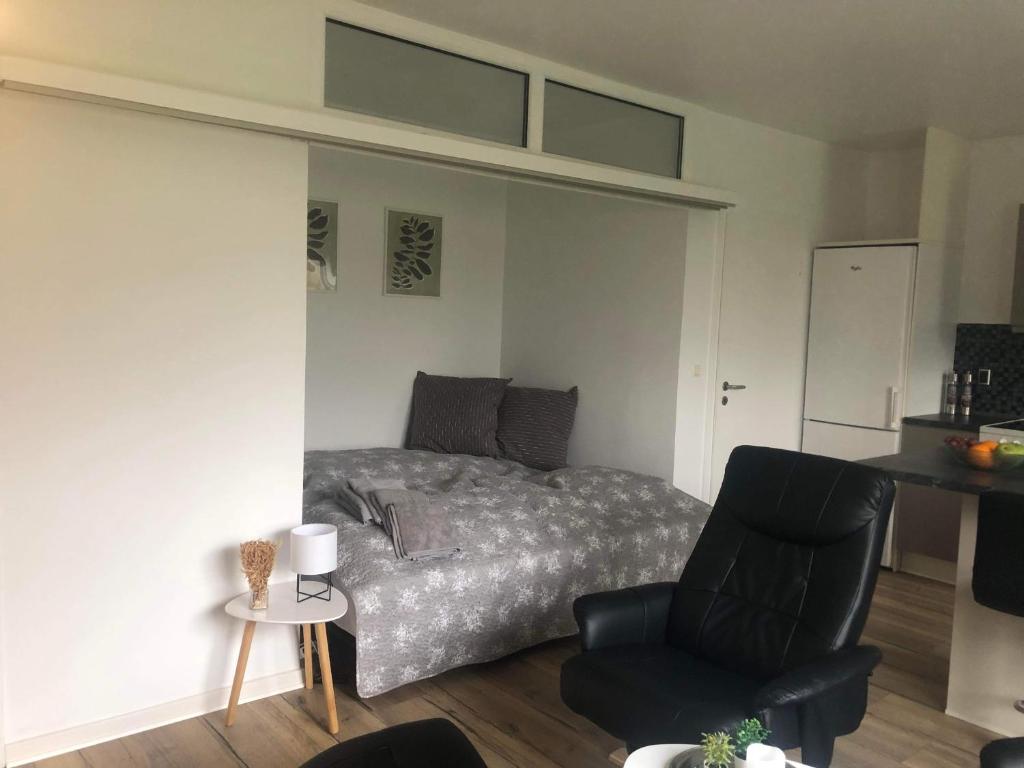 a bedroom with a bed and a chair at Grønnegade - tæt på Esbjerg C in Esbjerg