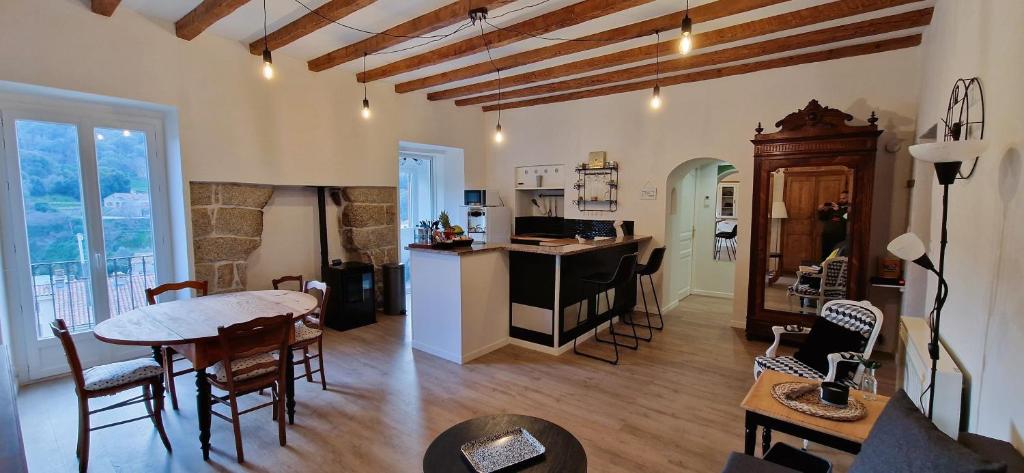 una cucina e un soggiorno con tavolo e sedie di Superbe T3 Idyllique avec vue sur les montagnes de l'Alta Rocca a Sartène