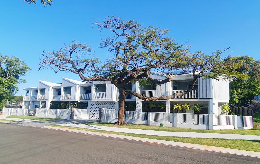 a white building with a tree in front of it at One on Harris Apartments in Wellington Point
