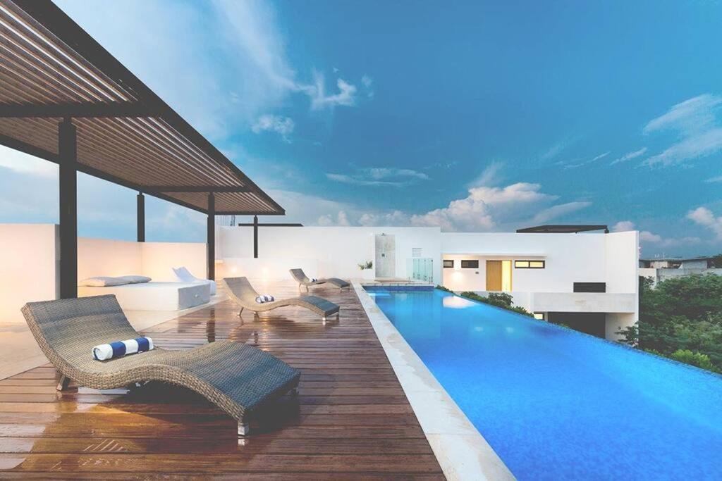 een zwembad met ligstoelen en een zwembad bij HIGHLINE 101 By SANDY POWERFUL in Tulum