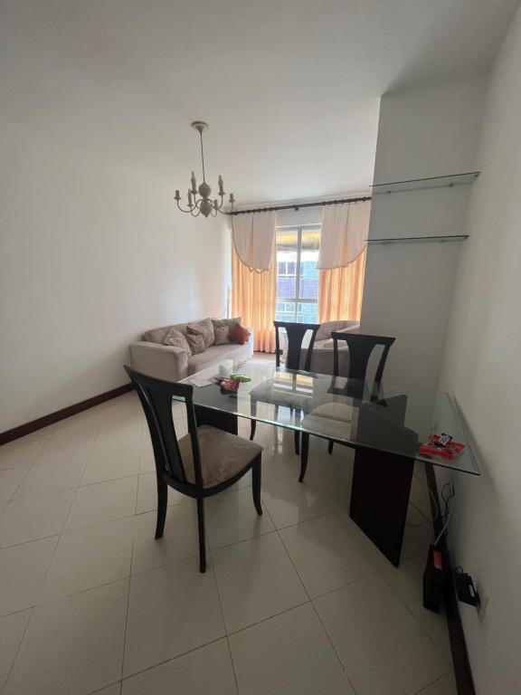 sala de estar con mesa, sillas y sofá en Apartamento 5min da praia no Rio Vermelho, en Salvador