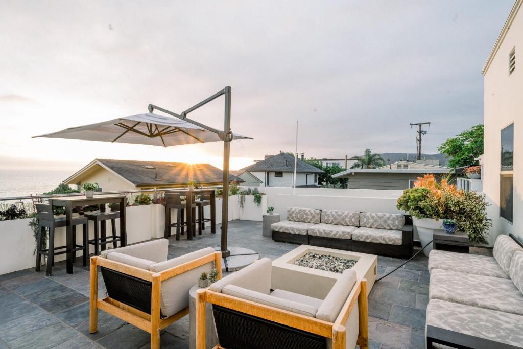 a rooftop patio with furniture and a bar at SCP Seven4One Hotel in Laguna Beach
