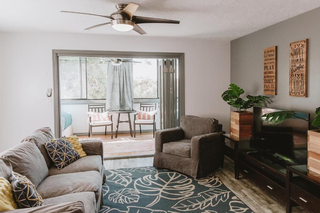 a living room with a couch and a television at Holualoa Gardens 101 in Kailua-Kona