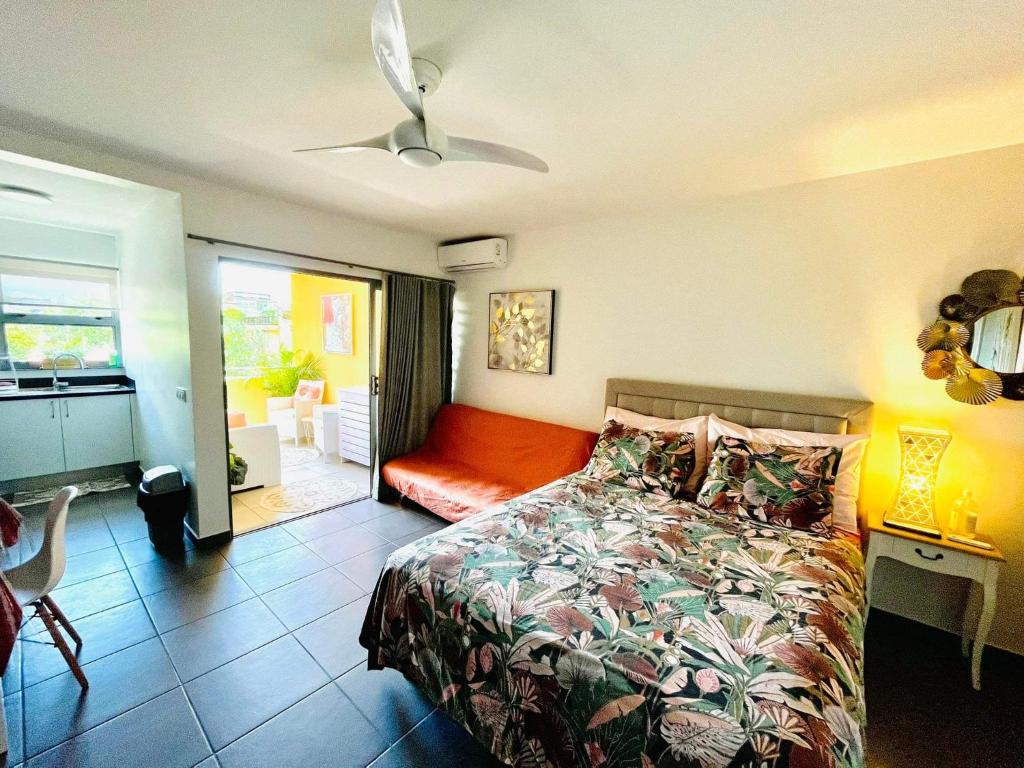 - une chambre avec un lit et un canapé dans l'établissement Tehautahi Cozy Lodge, à Papeete