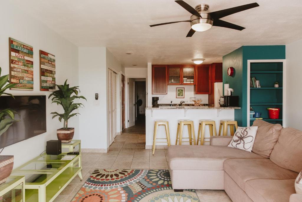 a living room with a couch and a kitchen at Holualoa Garden 103 in Kailua-Kona